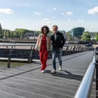 A couple crossing the bridge towards het Muziekgebouw aan 't IJ.