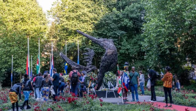 People gathering around the National Slavery Monument in the Oosterpark during Keti Koti Festival 2022.