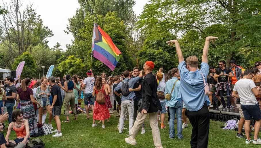 A group of people dancing and celebrating in the pride park