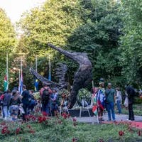 People gathering around the National Slavery Monument in the Oosterpark during Keti Koti Festival 2022.
