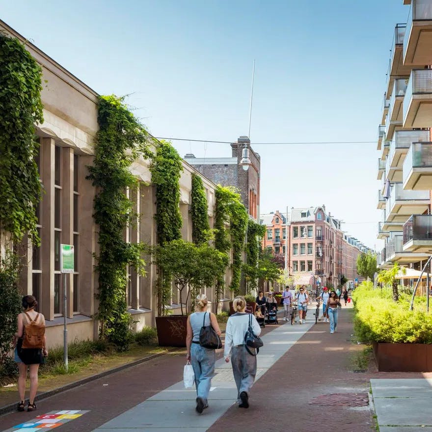 People walking over Hannie Dankbaarpassage next to De Hallen.