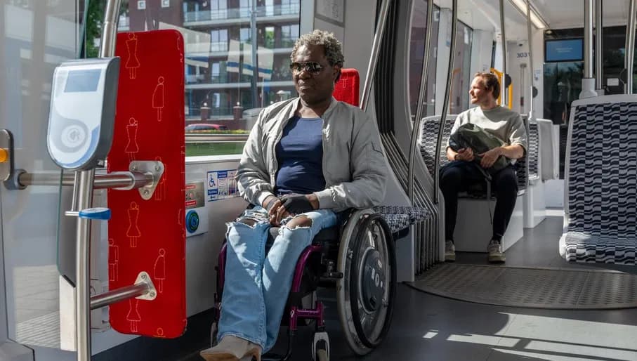 A person in a wheelchair on the tram in the designated location.