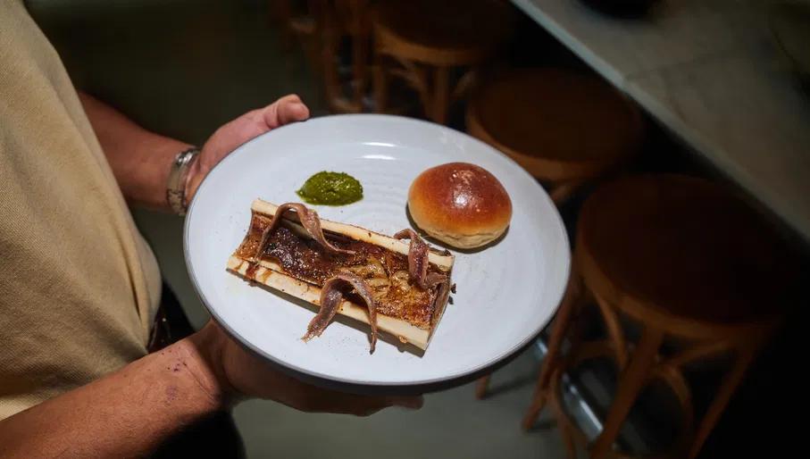 Waiter holding dish at Tiny Danser small plates restaurant in Oost