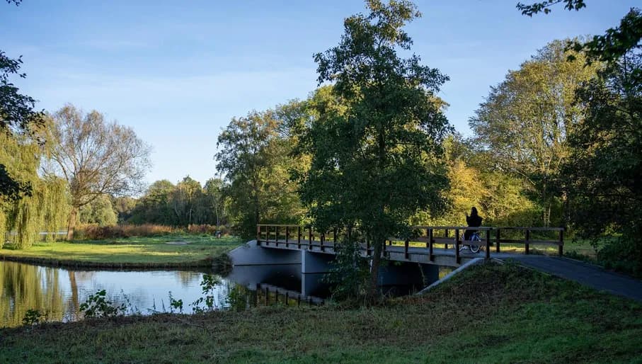 Girl cycling on the bridge in the Schellingwouderbreekpark. Content Creation Day in Amsterdam Noord, North