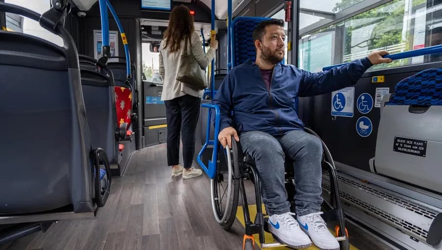 A person in a wheelchair on the bus in the designated location.