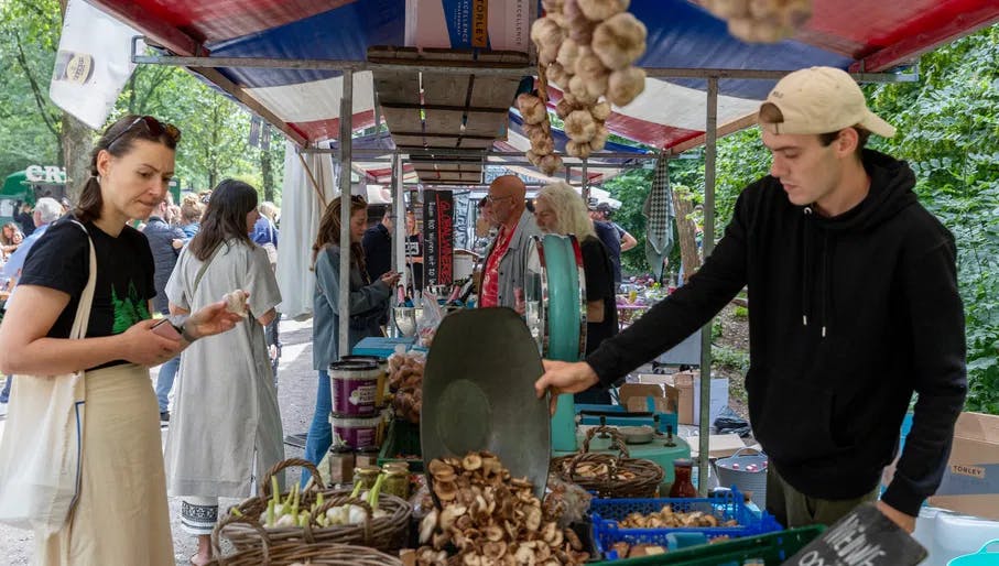 Man selling mushrooms and garlic at one of the stalls in the Pure Markt farmers market in the Amsterdamse Bos