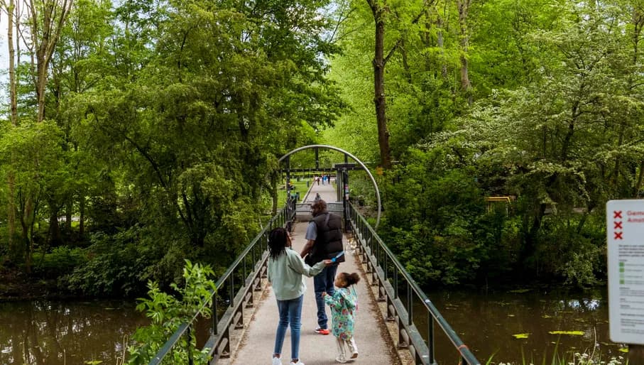 A family walks on the bridge towards Erasmuspark.