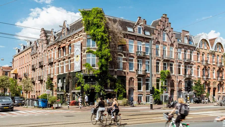 Cyclists cross Overtoom into the Tweede Constantijn Huijgensstraat.