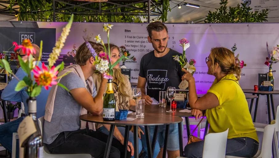 Visitors enjoying food at drinks at Haarlem Culinair food festival at the Grote Markt