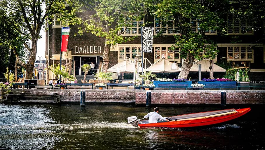 Baro Daalder terrace overlooking Canal with man on boat