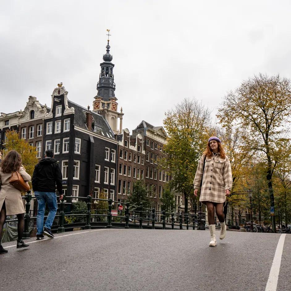 A woman walking over the Oost-Indische Huisbrug, on the background Kloveniersburgwal and Raamgracht.