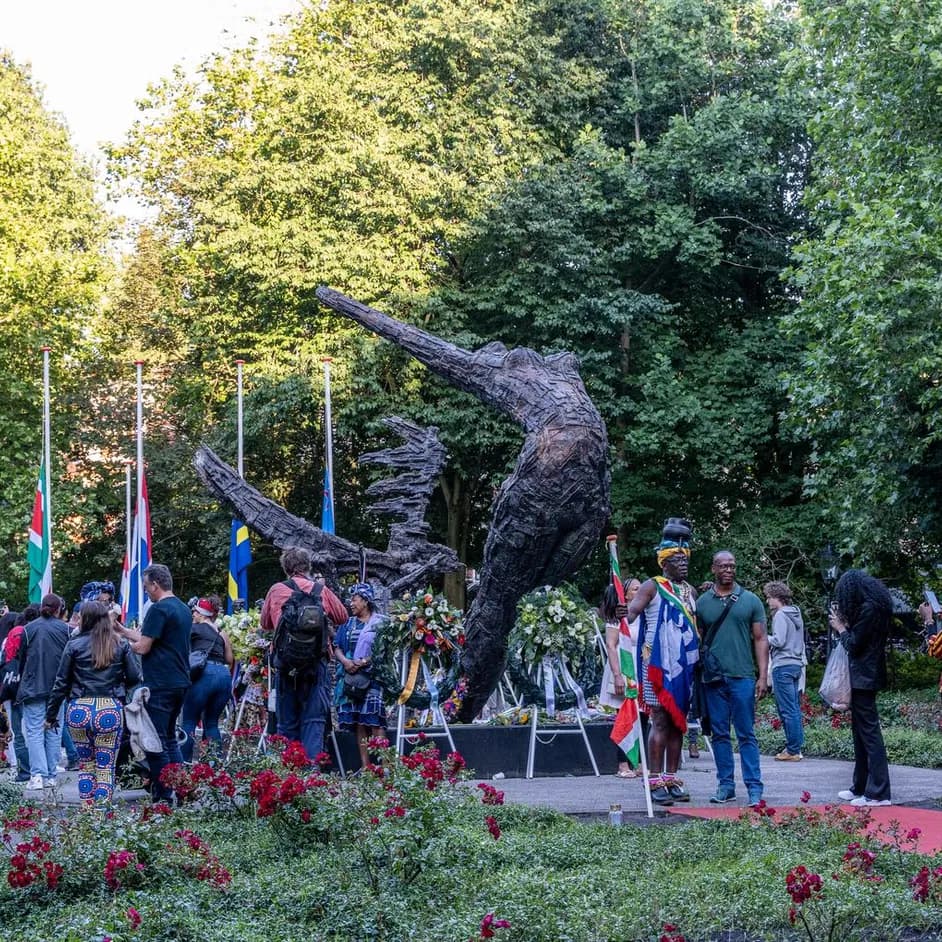 People gathering around the National Slavery Monument in the Oosterpark during Keti Koti Festival 2022.