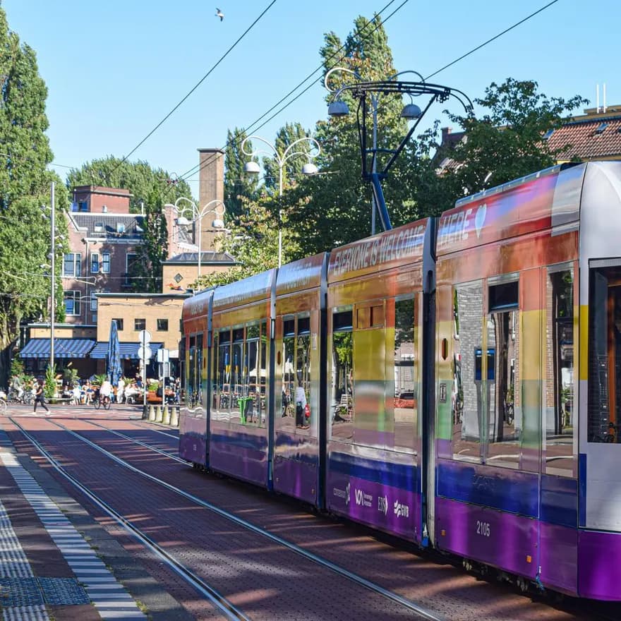 Colourful tram with Pride flag arriving at Javaplein.