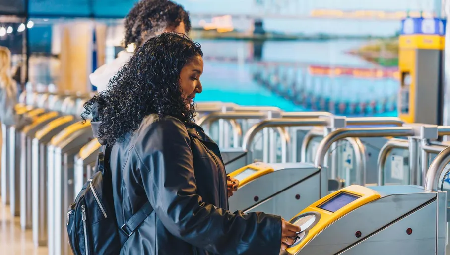 A woman goes through the public transport gates at Amsterdam Central Train station.