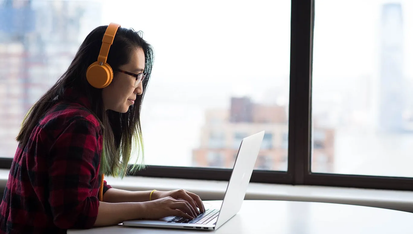 Woman working on laptop in high-rise building