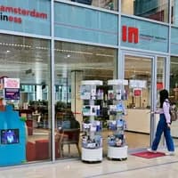 Woman with suitcase walking into the offices of INAmsterdam
