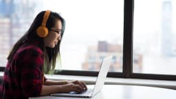Woman working on laptop in high-rise building