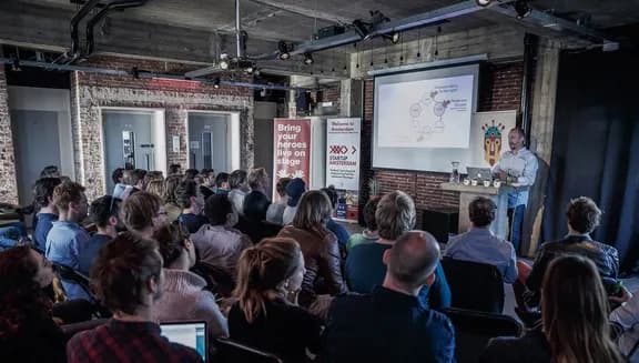 Someone presents on stage at a StartupAmsterdam event.