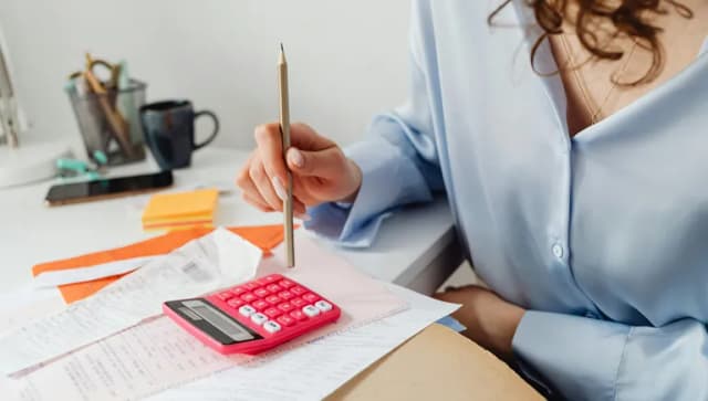Woman in an office doing taxes and finance calculations at a desk