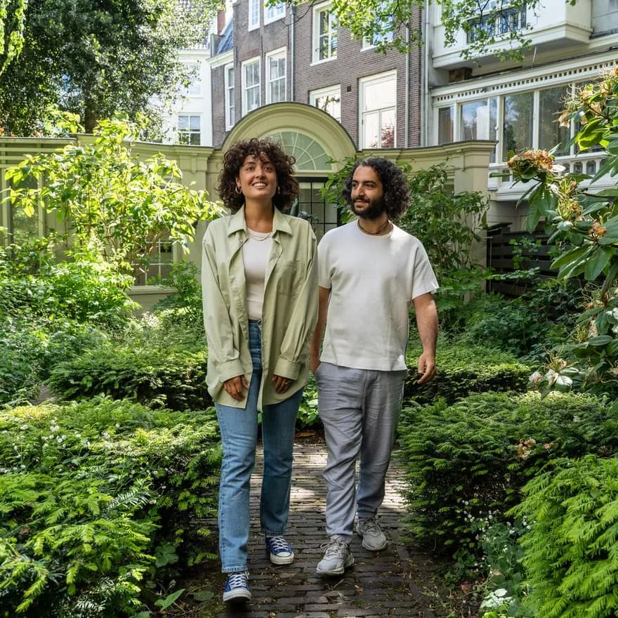 A couple walks trough the garden of Huis Marseille.