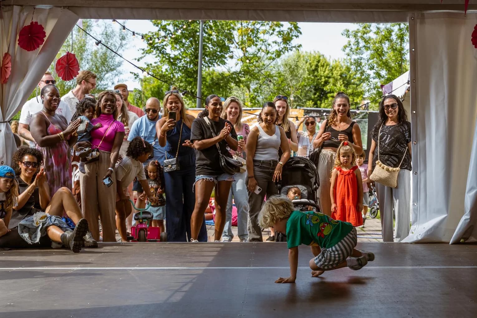 Parents watch while a boy shows his breakdance skills in the Kids Village at Kwaku Summer Festival 2024.