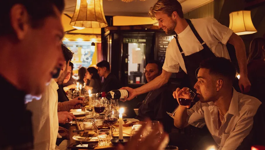 Waiter serving wine at Smelt cheese fondue restaurant