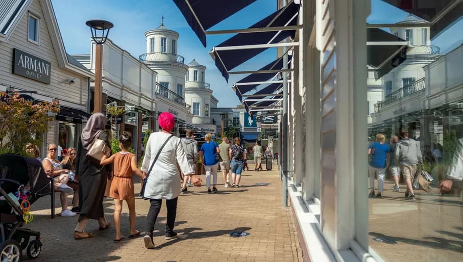 People holding hands and walking in the Bataviastad Outlet - Shop street