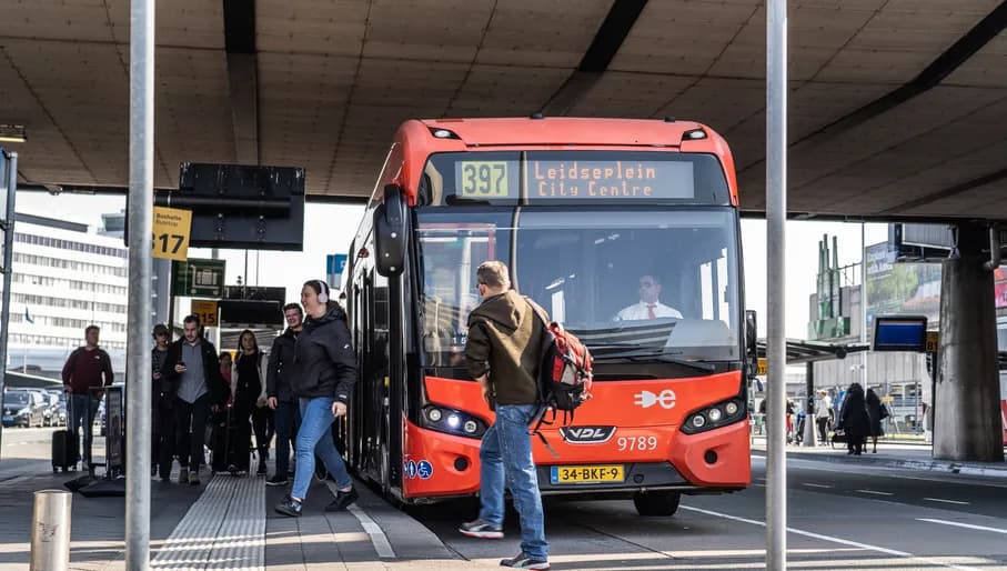Passengers boarding the Amsterdam Airport Express Bus outside Schiphol Airport.